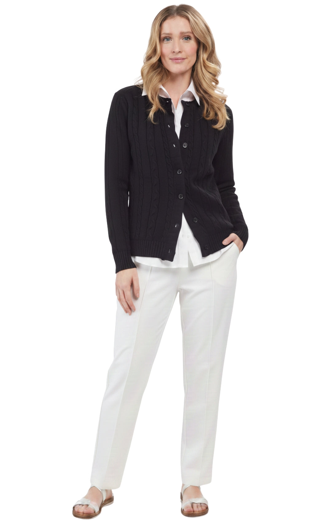 Woman wearing a black cardigan over a white shirt and pants on a white background
