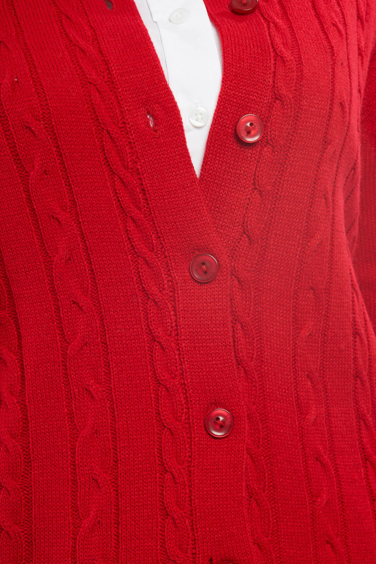 Close-up of a red cable knit cardigan with buttons
